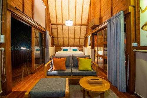 a bedroom with a bed and a couch and a table at Golo Nuk in Komodo Labuan Bajo Airport