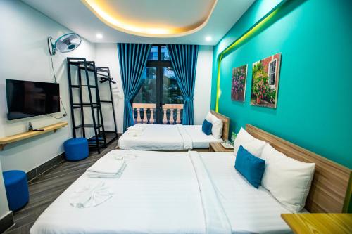 a hotel room with two beds and a tv at Teddy 96 Homestay & Cafe-3 stars-Grand World Phu Quoc in Phu Quoc