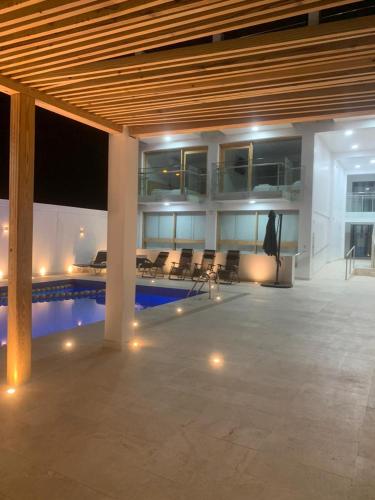 a large building with a swimming pool and a building with chairs at Hospedaje La Angostura in Ica