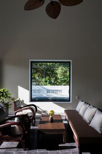 a living room with a couch and a large tv at Hoianoi Villa_A Little Hoi An_Entire villa in Hoi An