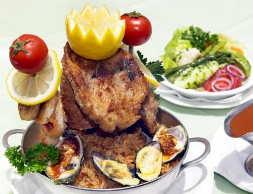 a plate of food with chicken and vegetables on a table at Hotel Deutsches Haus Swakopmund in Swakopmund