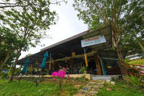 a restaurant with a sign in front of a building at Green Gen Hotel, Mueang Phuket in Phuket Town
