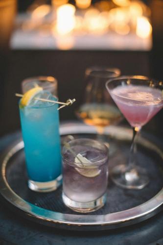 a tray with three cocktails on a table at The Clancy, Autograph Collection in San Francisco
