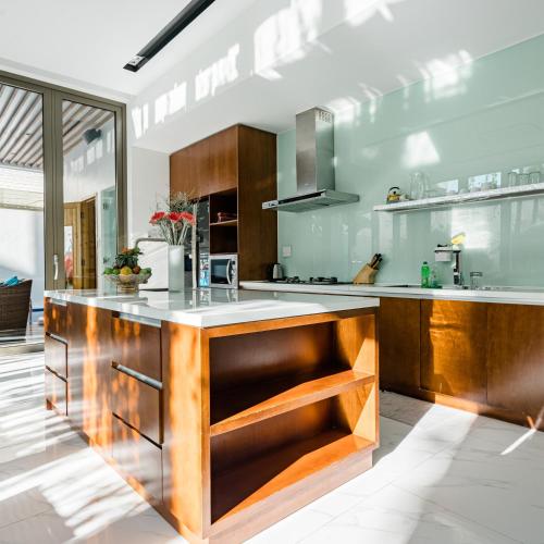 a kitchen with wooden cabinets and a counter top at Perfect Son Tra Beach Villa Da Nang with sea view in Danang