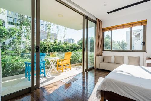a bedroom with a bed and sliding glass doors at Perfect Son Tra Beach Villa Da Nang with sea view in Danang