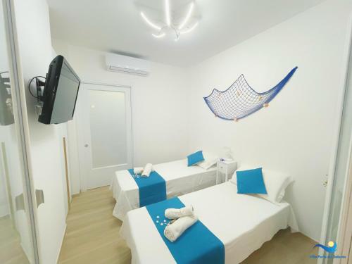 a small room with two beds and a tv at VILLA PERLA del SALENTO con piscina in Lido Marini