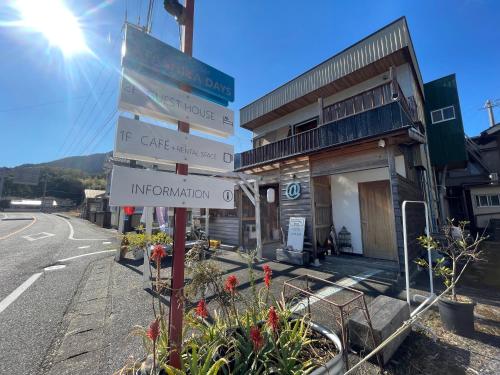 a street sign in front of a building at ATASHIKADAYS Kumano-Kodo Beachfront B&B Hostel in Kumano