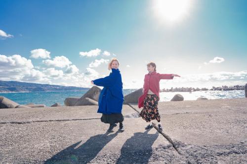 a man and a woman on the beach in skis at VacationHouse朔 海街さんぽ道 in Nahari