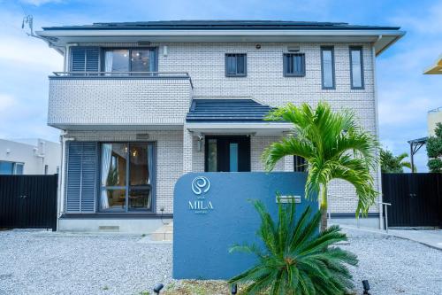 a house with a mla sign in front of it at Villa MILA MOTOBU in Motobu