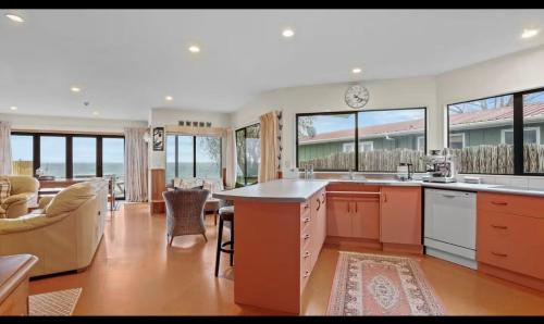 a large kitchen with a living room and a dining room at Lakefront House Stunning Sunsets in Waitahanui