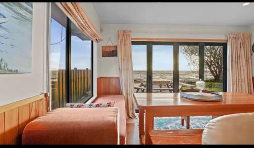 a dining room with a table and a view of the ocean at Lakefront House Stunning Sunsets in Waitahanui