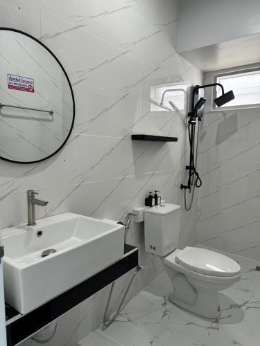 a white bathroom with a sink and a toilet at Ma Lay Resort in Ban Pheng Krong