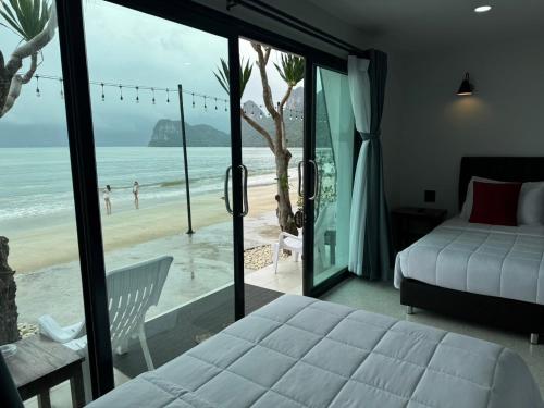 a bedroom with a bed and a view of the beach at Ma Lay Resort in Ban Pheng Krong