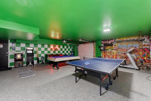a ping pong table in a room with a green wall at 5BR 5BA Architectural Estate-Theatre Gym Rooftop in Chicago