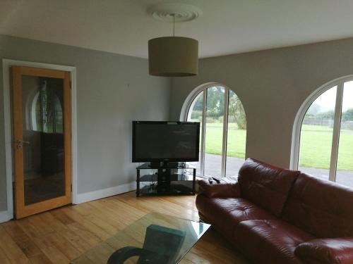 a living room with a couch and a flat screen tv at Ballyhoura Country Kildorrery, beautiful 5 bed in Kildorrery