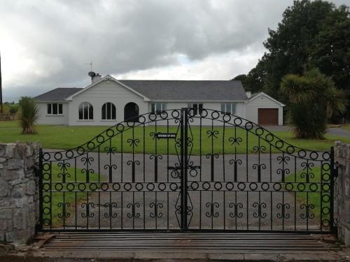 a black gate in front of a white house at Ballyhoura Country Kildorrery, beautiful 5 bed in Kildorrery