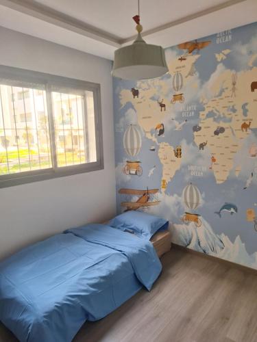 a bedroom with a blue bed and a wall with a map at Bel appartement familial résidence sécurisée in Casablanca