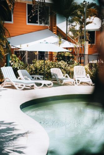 a group of chairs sitting next to a swimming pool at Sails Lifestyle Resort in Peregian Beach