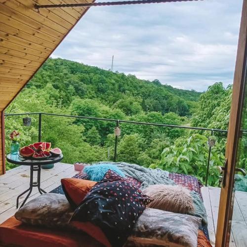 a couch on a deck with a view of a mountain at Cottage Sataplia in Kutaisi