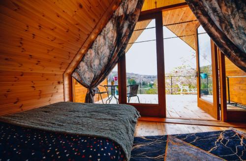 a bedroom with a bed and a large window at Cottage Sataplia in Kutaisi