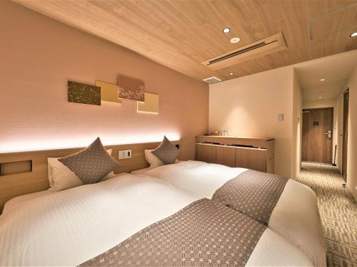 a bedroom with a large white bed with pillows at Stay SAKURA Kyoto Higashi Hongan-ji I in Kyoto