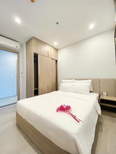 a bedroom with a large white bed with a flower on it at T-Plantino - Căn hộ Codotel The Sóng 5 Sao - Free swimmingpool, Gym, Sauna in Vung Tau