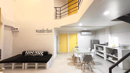 a living room with a table and a yellow door at Baan Khun Pra APT No4 Duplex 3BR in Bangkok