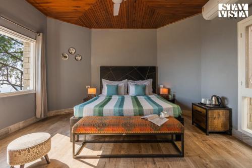 a bedroom with a bed and a wooden ceiling at StayVista at Serene with Outdoor Bonfire in Barog