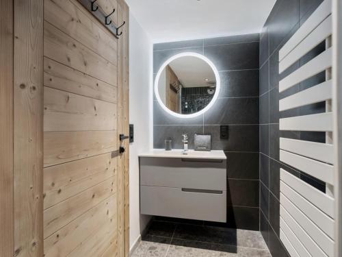 une salle de bain avec un lavabo et un miroir dans l'établissement Appartement moderne aux pieds des pistes avec WiFi, 4 chambres, 10 personnes - FR-1-570-65, à Levassaix