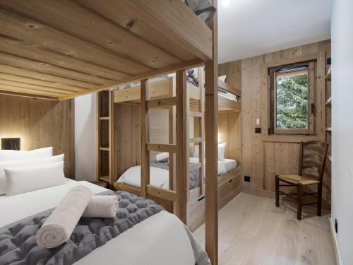 une chambre avec deux lits superposés et un bureau dans l'établissement Appartement moderne aux pieds des pistes avec WiFi, 4 chambres, 10 personnes - FR-1-570-65, à Levassaix
