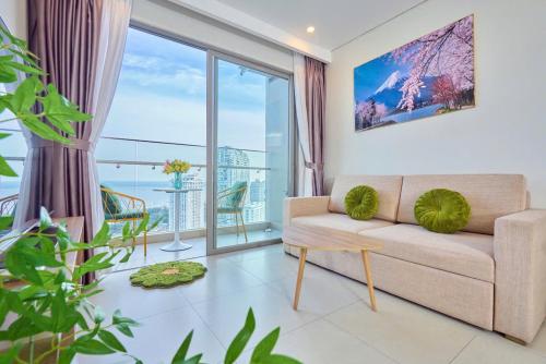 a living room with a couch and a large window at T-Plantino - Căn hộ Codotel The Sóng 5 Sao - Free swimmingpool, Gym, Sauna in Vung Tau