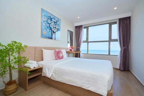 a bedroom with a large bed and a window at T-Plantino - Căn hộ Codotel The Sóng 5 Sao - Free swimmingpool, Gym, Sauna in Vung Tau