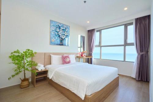 a bedroom with a bed and a large window at T-Plantino - Căn hộ Codotel The Sóng 5 Sao - Free swimmingpool, Gym, Sauna in Vung Tau