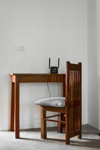 a wooden desk with a chair and a telephone at Bali Villa Mirissa in Mirissa