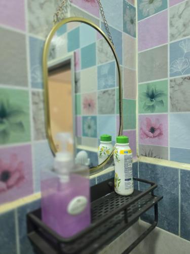 a bathroom sink with a mirror and a bottle of soap at 103 Olan Place Apartment with fan and near SkyTrain and free Wi-Fi in Bangkok