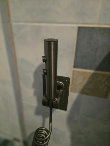 a metal toilet paper dispenser on a wall at 103 Olan Place Apartment with fan and near SkyTrain and free Wi-Fi in Bangkok