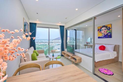 a bedroom with a bed and a dining room with a table at T-Plantino - Căn hộ Codotel The Sóng 5 Sao - Free swimmingpool, Gym, Sauna in Vung Tau