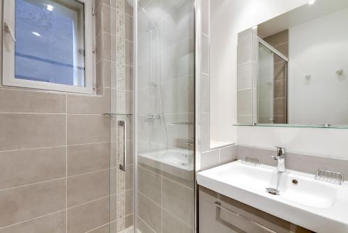 un bagno con doccia, lavandino e specchio di Le Vintage a Parigi