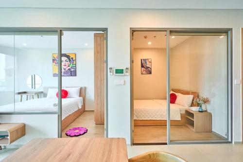 a room with two beds and a glass wall at T-Plantino - Căn hộ Codotel The Sóng 5 Sao - Free swimmingpool, Gym, Sauna in Vung Tau