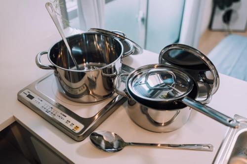 a pair of utensils on a counter next to two spoons at Minimalist Loft Namba Compact Studio with a 24-hour Gym MA1003 in Osaka