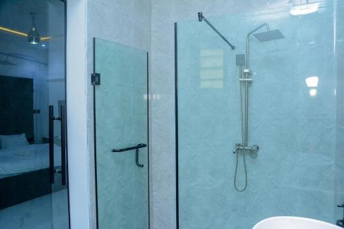 a shower with a glass door in a bathroom at Stylish Haven, Luxe & Cozy in Mama