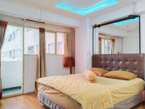 1 dormitorio con 1 cama grande y techo azul en The Royale Sentra Tower Kuning Powered by Cocotel, en Yakarta