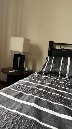 a black and white bed with a lamp on a table at Posadita la María in Córdoba