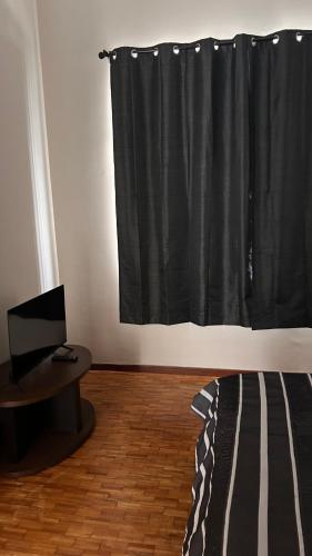 a bedroom with a bed and a black curtain at Posadita la María in Córdoba