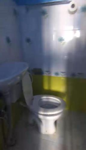 a bathroom with a white toilet and a sink at Sunshine Guest House & Restaurant in Dhunche