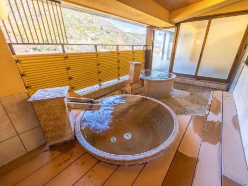 a bathroom with a large bowl sink and a window at Hakoneji Kaiun in Hakone