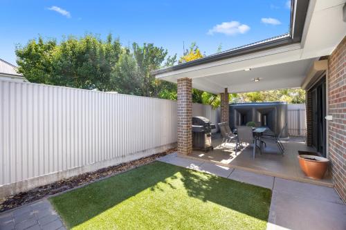 a small backyard with a white fence and grass at Largs Tides - 3BR, BBQ, Parking in Peterhead