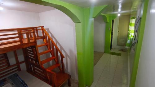 a bathroom with green walls and a staircase and a shower at Guanna's Place Room and Resto Bar in Malapascua Island