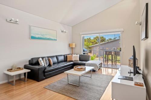 a living room with a black leather couch at Villa Sedici @ Cape Villas Dunsborough in Dunsborough