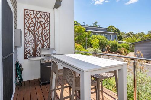 a patio with a white table and chairs on a balcony at Villa Sedici @ Cape Villas Dunsborough in Dunsborough